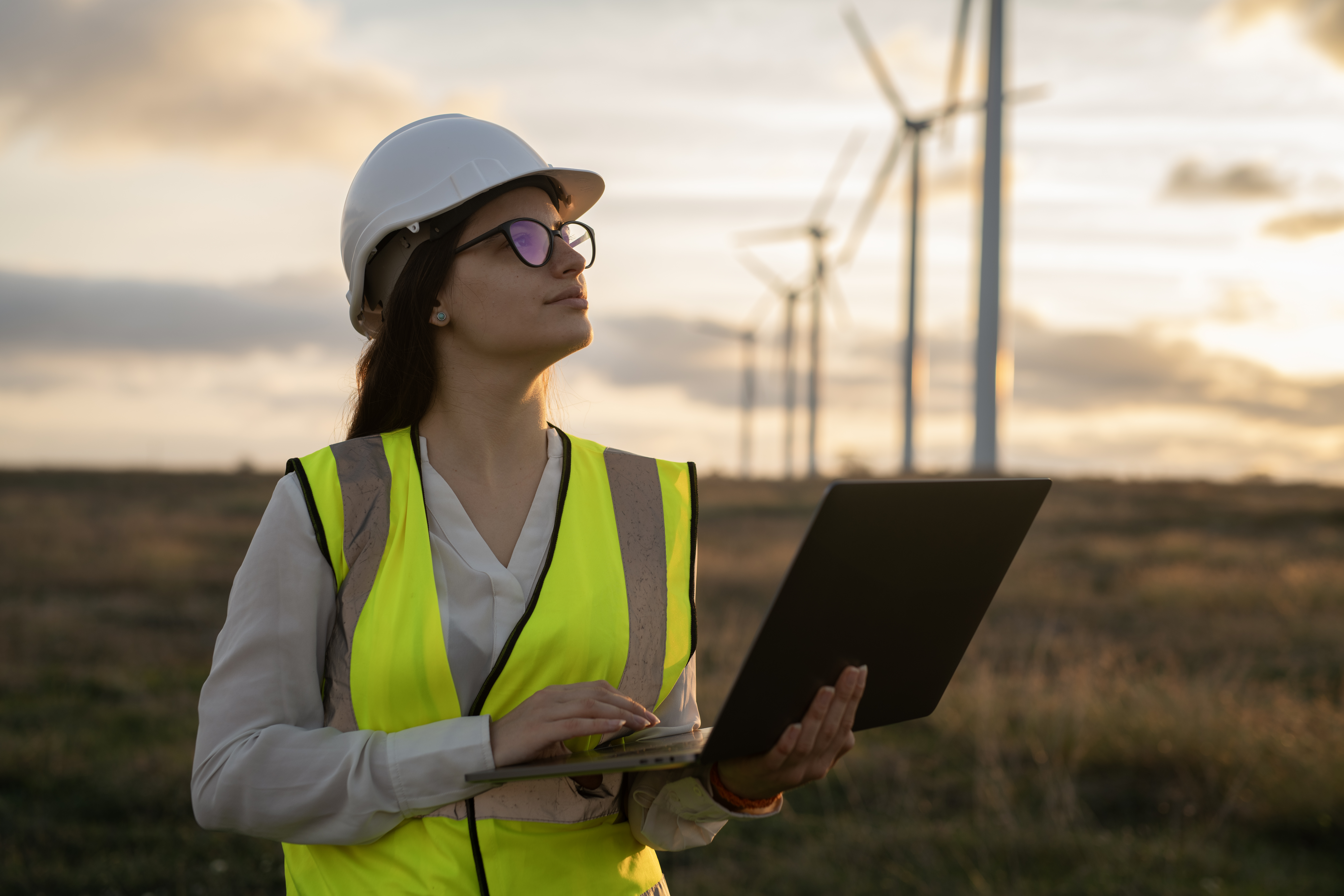 Photo of engineer with wind farm on the background. Credit Getty Images