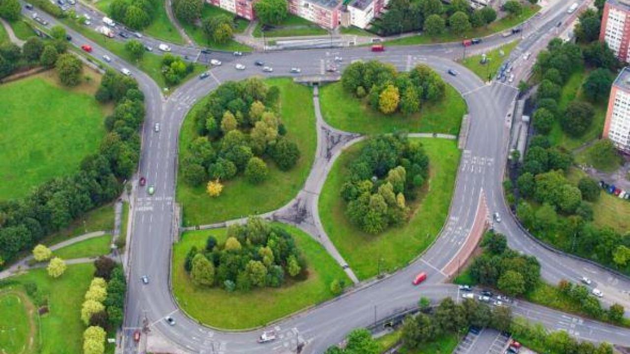 Picture of big roundabout with green trees and grass in the middle