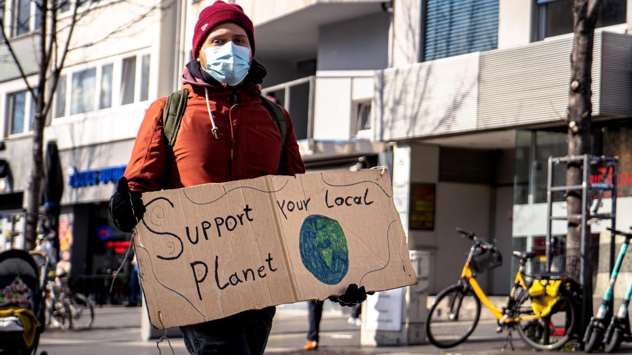 Protester carries placard saying "Support Planet"
