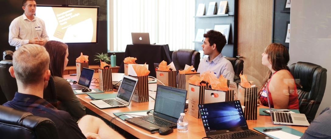 People in a meeting looking at someone presenting. Photo by Campaign Creators on Unsplash