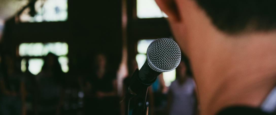 Photo of someone in front of a microphone. Photo by Marcos Luiz Photograph on Unsplas