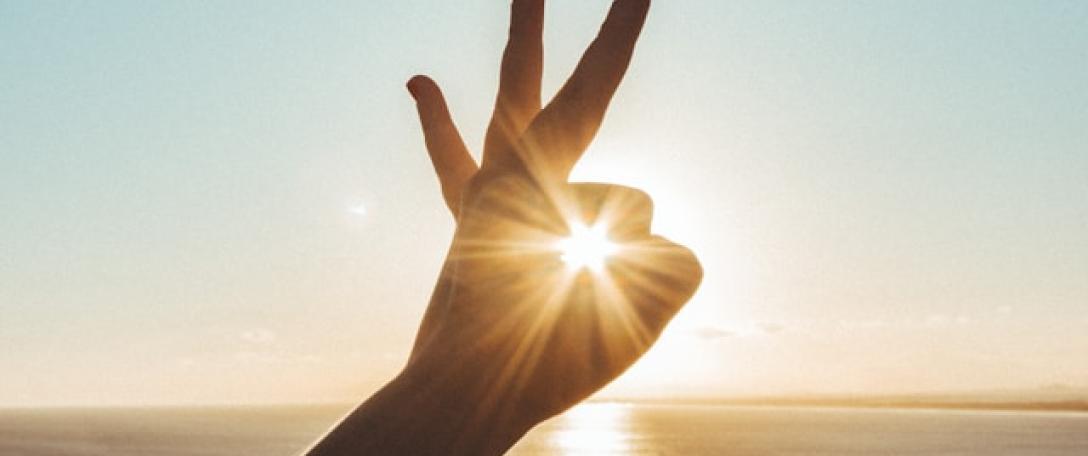 Hand pretending to hold the sun. Photo by Victor Freitas on Unsplash