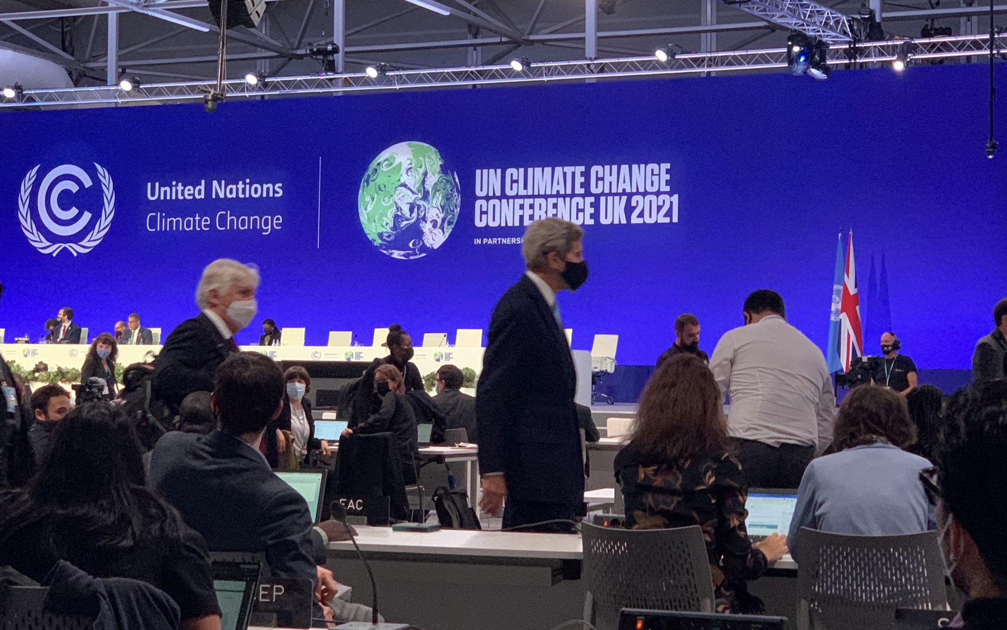 US ambassador John Kerry walks in front of the stage at COP26. 