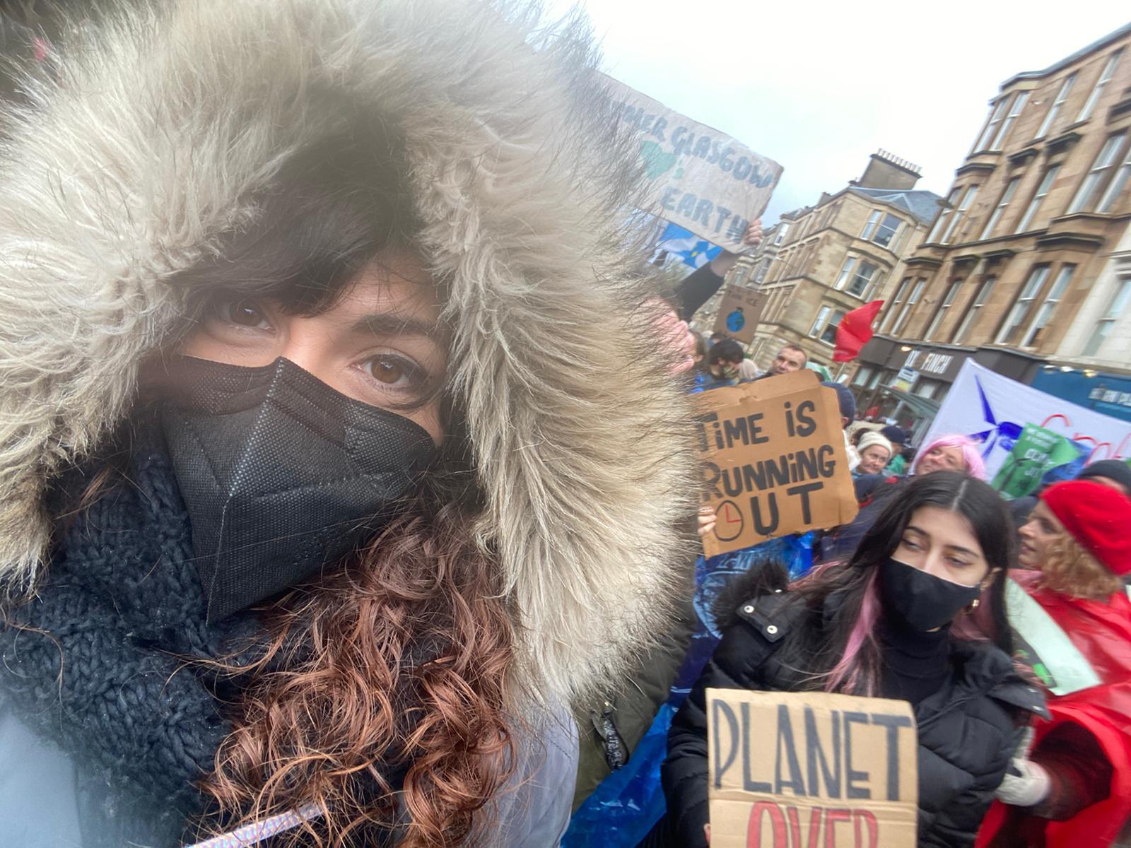 Dr Cristina Peñasco in a mask at the COP26 march. A placard behind her reads 'time is running out'. 