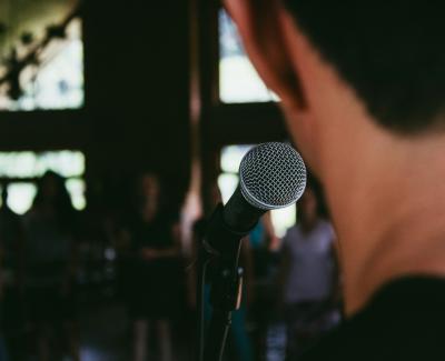 Photo of someone in front of a microphone. Photo by Marcos Luiz Photograph on Unsplas