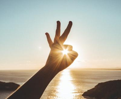 Hand pretending to hold the sun. Photo by Victor Freitas on Unsplash